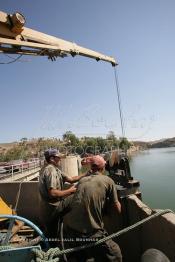 Image du Maroc Professionnelle de  Des ouvrier s'activent sur un engin servant au  nettoyage du Barrage Machraa Hamadi dont la capacité est de 42 Millions de m3, est construit sur l'Oued Moulouya, il permet, depuis 1956, d'approvisionner la région et d'irriguer les terres de cultures, ce barrage fournit en eau potable les ville de Nador, Oujda, il permet également l'approvisionnement des centre de Taourirte et El Aïoun Sidi Mellouk. Samedi 1er octobre 2005. (Photo / Abdeljalil Bounhar)